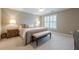 Spacious main bedroom featuring neutral walls, carpet, bench, a ceiling fan, and large windows with plantation shutters at 1364 Gulfport Run, Grayson, GA 30017