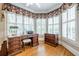 Office space with hardwood floors, a large bay window with custom drapes, a desk, and office furniture at 1364 Gulfport Run, Grayson, GA 30017