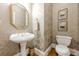 Elegant powder room featuring patterned wallpaper, a pedestal sink, and hardwood floors at 1364 Gulfport Run, Grayson, GA 30017