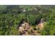 An aerial view of a wooded property reveals the main residence, horse arena, and a secondary building at 1369 N Highway 16, Whitesburg, GA 30185