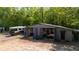 A large barn with multiple bays sits near a camper, surrounded by trees, offering ample storage and workspace at 1369 N Highway 16, Whitesburg, GA 30185