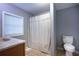 Bathroom with window and white blinds, neutral wall paint, striped shower curtain, and toilet at 1369 N Highway 16, Whitesburg, GA 30185