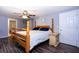 Bedroom featuring dark wood floors, a ceiling fan, and a wooden bed frame with blue pillows at 1369 N Highway 16, Whitesburg, GA 30185