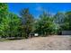Full lot view showing many mature trees and a few small structures at 1369 N Highway 16, Whitesburg, GA 30185