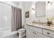 Bathroom with a bathtub and shower, a white vanity with granite countertops, and modern lighting at 260 Jasmine Garden Way, Alpharetta, GA 30009