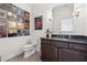 Modern bathroom with dark cabinets, stone countertop, decorated with framed vinyl records and decorative lighting at 260 Jasmine Garden Way, Alpharetta, GA 30009