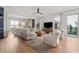 Open living room with hardwood floors, large windows, modern furniture, and a ceiling fan at 260 Jasmine Garden Way, Alpharetta, GA 30009