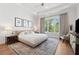 Bright bedroom with a tray ceiling, large window, and stylish furniture at 260 Jasmine Garden Way, Alpharetta, GA 30009