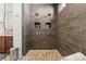 Stylish shower with dual shower heads, gray tiling, built-in shelves, and a pebble-stone floor at 260 Jasmine Garden Way, Alpharetta, GA 30009