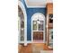 Hallway featuring hardwood floors, blue wallpaper, and arched entryways to kitchen and dining area at 511 Sycamore St, Decatur, GA 30030