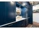 Elegant hallway featuring navy blue cabinetry with gold hardware and a marble countertop with a vintage light fixture at 511 Sycamore St, Decatur, GA 30030