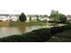 Backyard featuring a tranquil lake, lush greenery, and neighborhood homes at 1920 Stancrest Nw Trce, Kennesaw, GA 30152