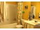 Bathroom features a tub with white tile surround, vanity with sink, and colorful yellow paint at 1920 Stancrest Nw Trce, Kennesaw, GA 30152
