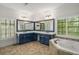This bathroom includes a large soaking tub, dual vanities, beautiful tile flooring, and natural light from two windows at 201 Hunley Ct, Alpharetta, GA 30005