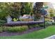 Stone entrance to Creekside Place, framed by colorful flowers and manicured landscaping at 201 Hunley Ct, Alpharetta, GA 30005