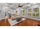 Bright living room features hardwood floors, a ceiling fan, and an open floor plan with a view to the kitchen at 201 Hunley Ct, Alpharetta, GA 30005
