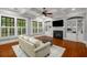 Cozy living room with a fireplace, built-in shelves, hardwood floors, and large windows at 201 Hunley Ct, Alpharetta, GA 30005