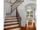 Inviting staircase with hardwood steps and wrought iron railing leading to the upper level of the home at 201 Hunley Ct, Alpharetta, GA 30005
