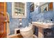 Bathroom featuring textured blue walls, toilet, pedestal sink, and window offering natural light at 4111 Mcclatchey Ne Cir, Atlanta, GA 30342