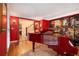 Well-lit piano room with hardwood floors, walls painted red and an entry to the home's staircase at 4111 Mcclatchey Ne Cir, Atlanta, GA 30342