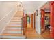 Elegant staircase with hardwood floors leading to the upper level and a foyer featuring a red door at 4111 Mcclatchey Ne Cir, Atlanta, GA 30342