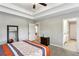 Spacious bedroom with tray ceiling, neutral paint, and access to an ensuite bathroom at 461 Silver St, Buford, GA 30518