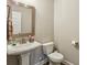 Well-lit powder room with modern fixtures, neutral tones, and a pedestal sink at 461 Silver St, Buford, GA 30518