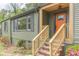 Charming home with freshly painted exterior, new wooden stairs leading to a vibrant orange front door at 525 Rosemont Dr, Decatur, GA 30032