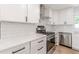 Modern kitchen with stainless appliances, quartz countertops, and subway tile backsplash at 525 Rosemont Dr, Decatur, GA 30032