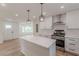 Bright and airy kitchen boasts stainless appliances, sleek white cabinets, and island seating for easy meal prep and entertaining at 525 Rosemont Dr, Decatur, GA 30032