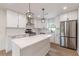 Stunning kitchen featuring stainless steel appliances, white cabinets and countertops, and an island with pendant lighting at 525 Rosemont Dr, Decatur, GA 30032