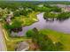 Aerial view of a neighborhood near a scenic lake surrounded by trees and winding trails at 590 Birkdale Dr, Fairburn, GA 30213