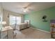Cozy bedroom featuring neutral carpet, a ceiling fan, a desk, and a large window for natural light at 590 Birkdale Dr, Fairburn, GA 30213