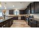 Modern kitchen with stainless steel appliances, dark cabinets, granite counters, and wood-look flooring at 590 Birkdale Dr, Fairburn, GA 30213