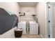 Functional laundry room featuring a washer, dryer, overhead rack, and painted accent wall at 590 Birkdale Dr, Fairburn, GA 30213