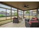 Screened-in sunroom has comfortable seating and views of the backyard at 590 Birkdale Dr, Fairburn, GA 30213