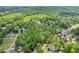 Expansive aerial view showing homes and a large, lush green field in a serene, wooded neighborhood at 6230 Lillie Lane, Cumming, GA 30040