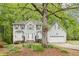 Inviting home with large tree in front and a well-manicured lawn at 6230 Lillie Lane, Cumming, GA 30040