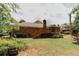 Large backyard with a wood deck, mature trees, and a brick house at 3572 Stone Ridge Trl, Douglasville, GA 30134