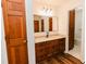 Beautiful bathroom with granite countertop, wooden cabinets, and wood-look floors at 3572 Stone Ridge Trl, Douglasville, GA 30134