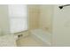 Bright bathroom featuring a white tiled bathtub and a window with blinds at 3572 Stone Ridge Trl, Douglasville, GA 30134