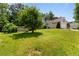 Large backyard with green grass and a shed surrounded by mature trees at 6416 Chestnut Glen Dr, Norcross, GA 30071