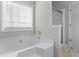 This primary bathroom features a corner tub with a view from a nearby window plus a glass-doored shower at 6416 Chestnut Glen Dr, Norcross, GA 30071