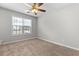 This bedroom features a ceiling fan, a window overlooking the property, and fresh neutral paint at 6416 Chestnut Glen Dr, Norcross, GA 30071