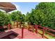 An elevated red deck overlooks lush greenery and mature trees, offering a private outdoor space at 6416 Chestnut Glen Dr, Norcross, GA 30071