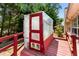 Features a small, backyard greenhouse with wooden supports, next to the main structure, and surrounded by mature trees at 6416 Chestnut Glen Dr, Norcross, GA 30071