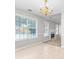 Bright living room with a fireplace, tiled flooring, a golden chandelier, and large windows with views at 6416 Chestnut Glen Dr, Norcross, GA 30071