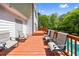 A wooden deck with outdoor seating overlooking a swimming pool and wooded area at 664 Somerset Dr, Lawrenceville, GA 30046