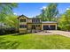 Charming yellow two-story home featuring a well-manicured lawn, an attached two-car garage, and mature trees at 664 Somerset Dr, Lawrenceville, GA 30046