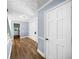 Hallway with hardwood floors and neutral-toned paint, offering multiple entryways into other rooms at 664 Somerset Dr, Lawrenceville, GA 30046